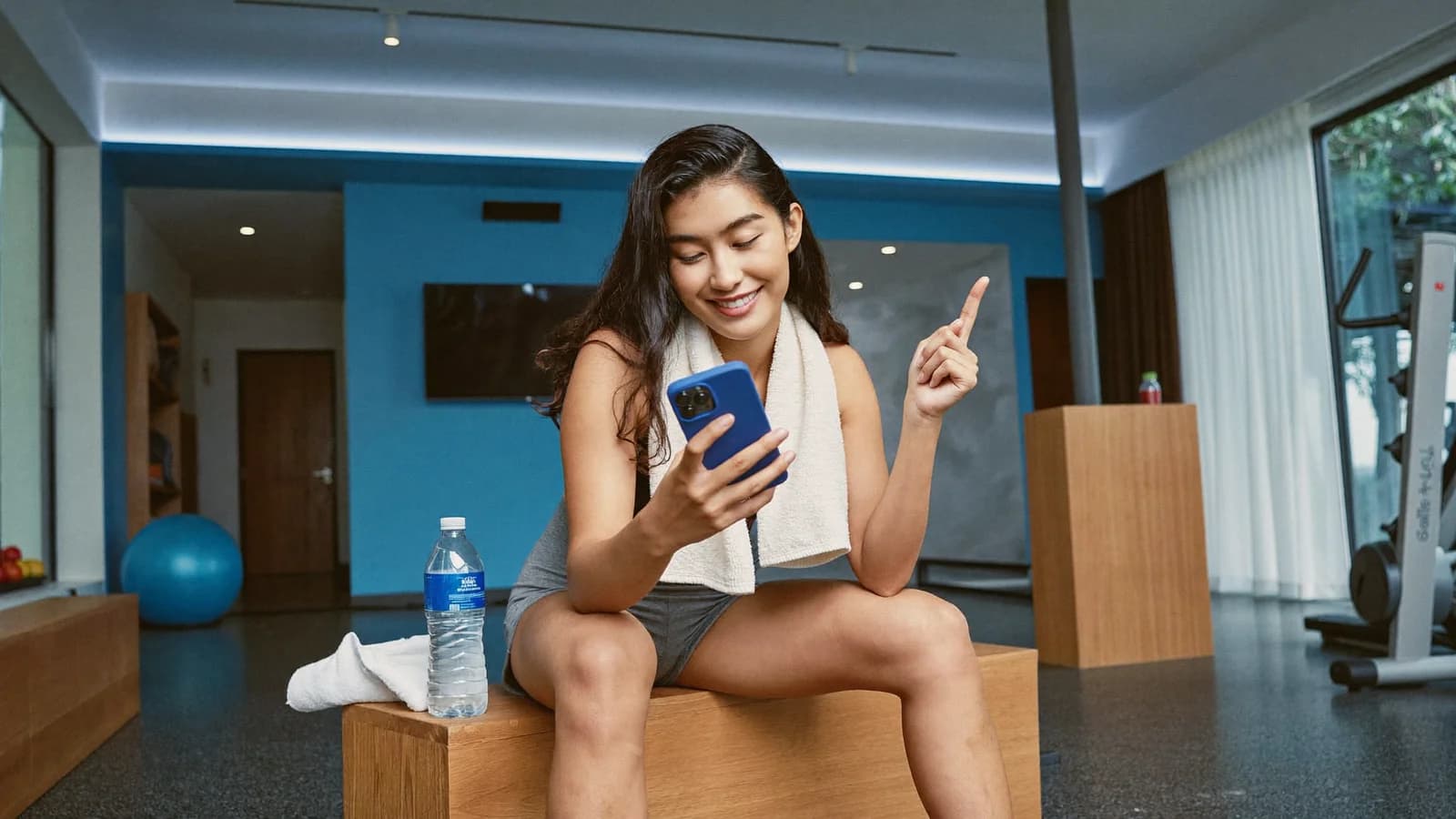 Aluna conferindo o resultado do treino no celular após a aula