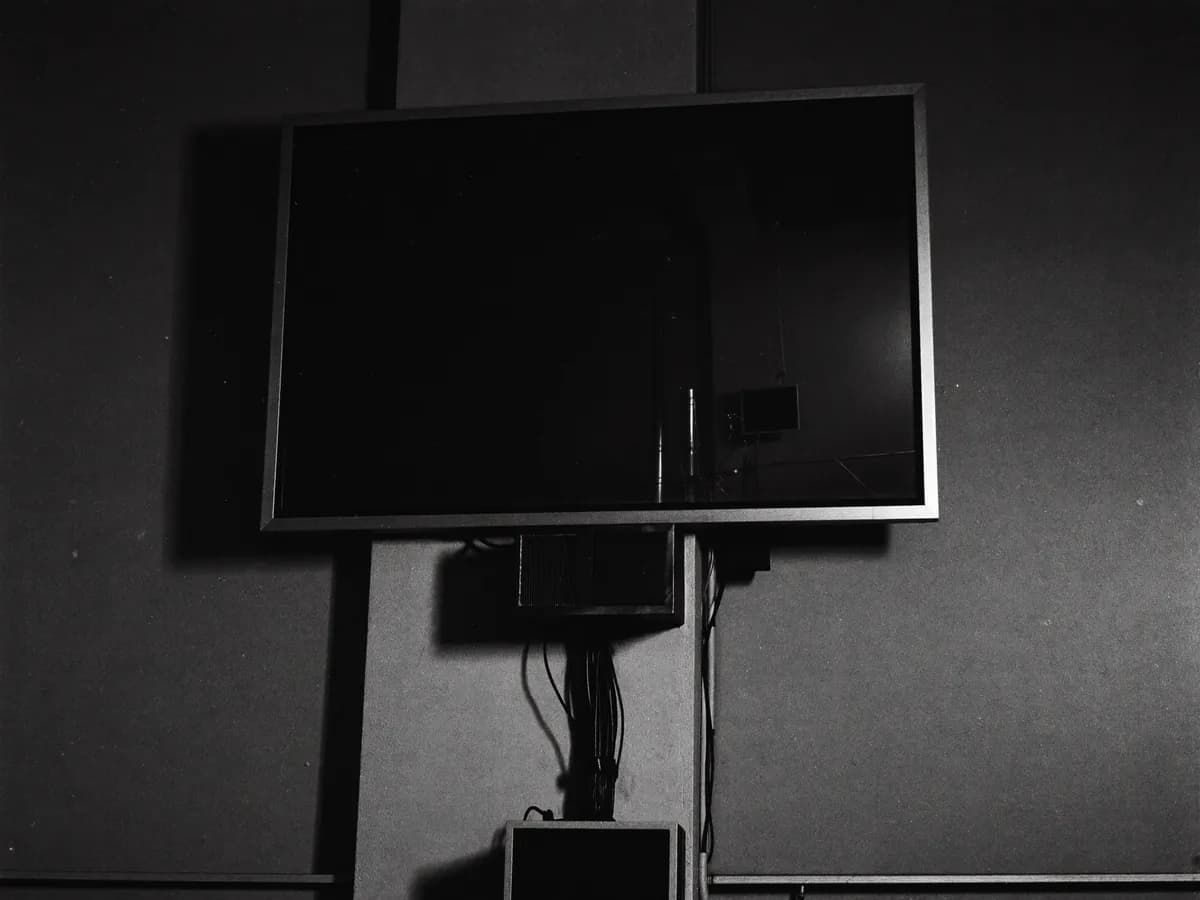 TV presa na parede com eletroduto e caixa fixa, tela apagada, sala vazia